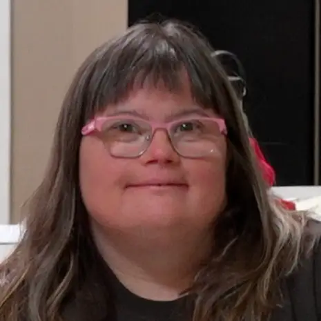 woman with glasses smiling straight ahead