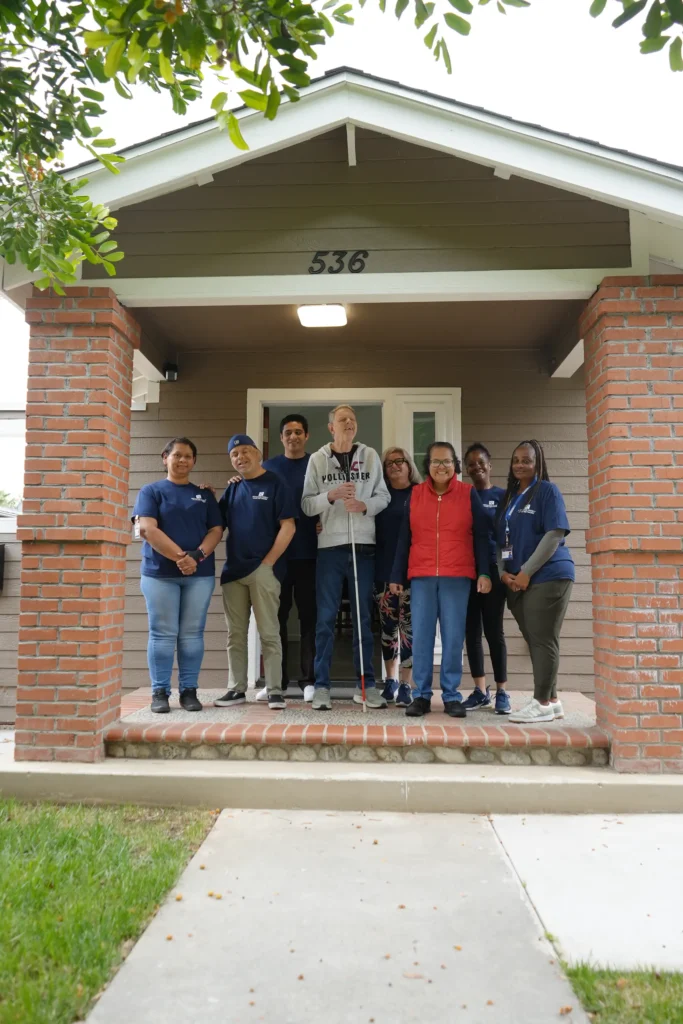 caregivers and individuals standing together on a porch smiling