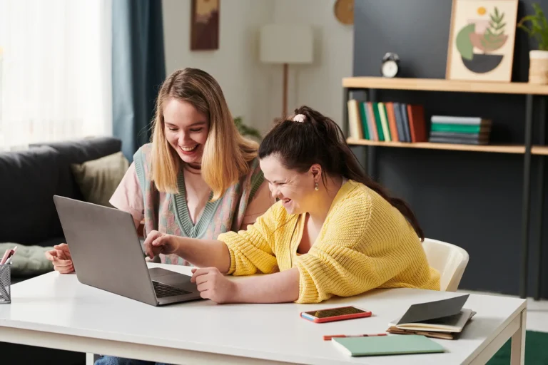 woman with individual on a laptop smiling