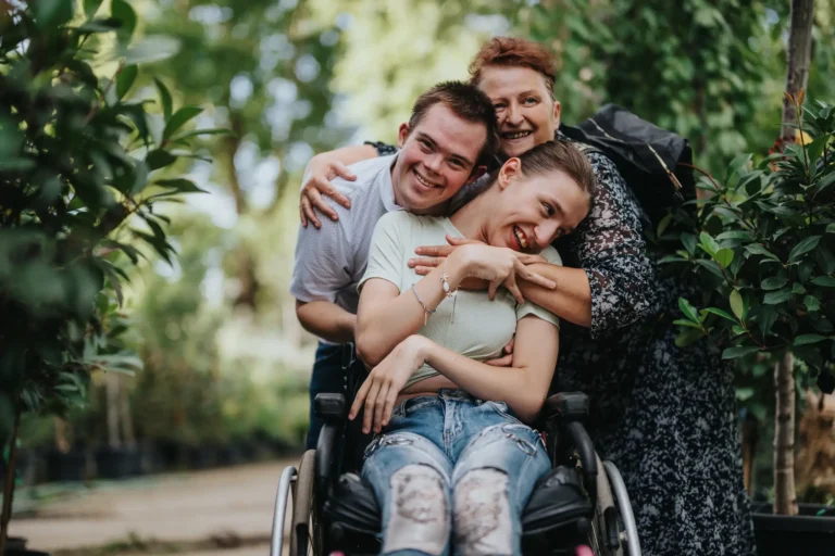 two women one in a wheelchair and a man all smiling