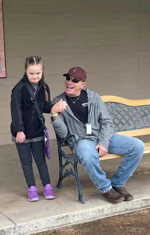 father sitting down holding hands with daughter