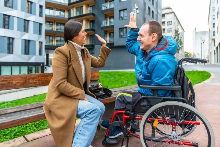 caregiver hi-fiving an individual in a wheelchair