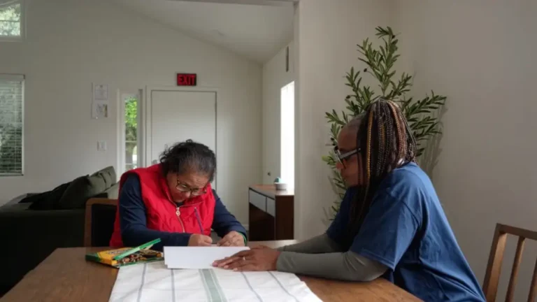 caregiver helping an individual write