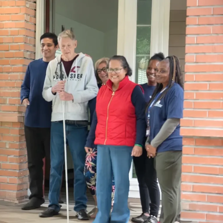 group of individuals with caregivers on a porch