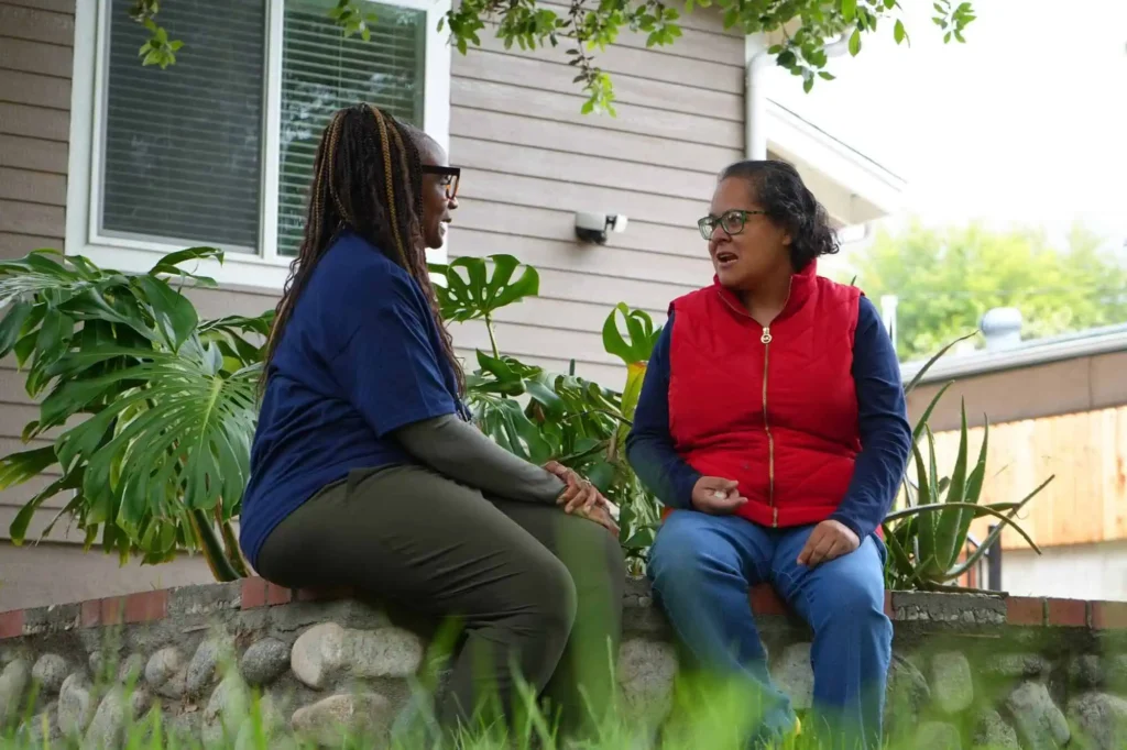 Two women talking while sitting outside