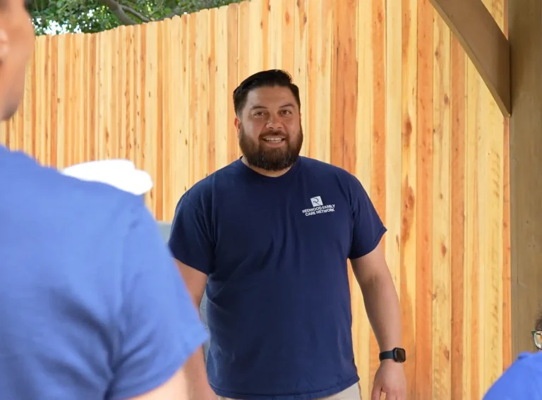 Redwood caregiver smiling underneath a patio cover