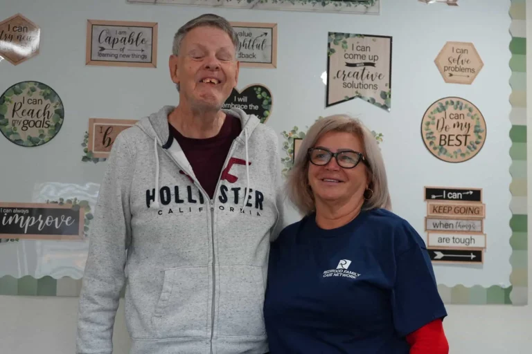Man and woman standing in front of quotes on a pinboard