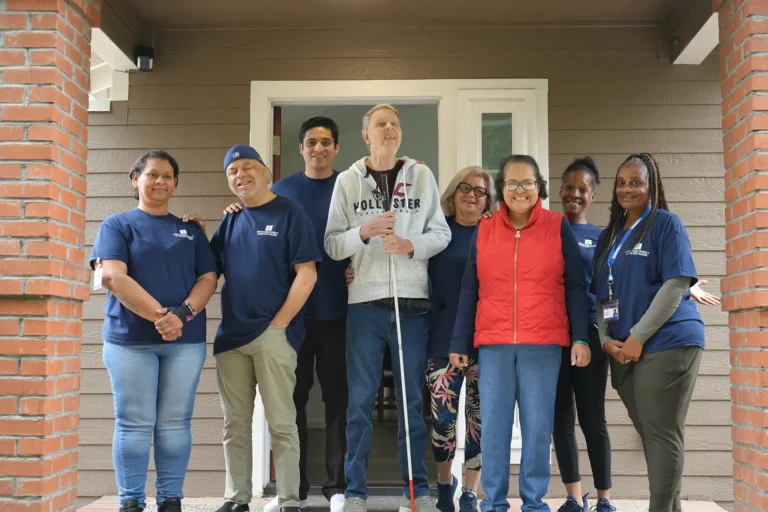 group of caregivers and individuals smiling on a porch