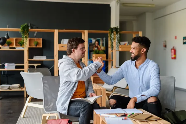 Young man with Down syndrome greeting his special educator teacher