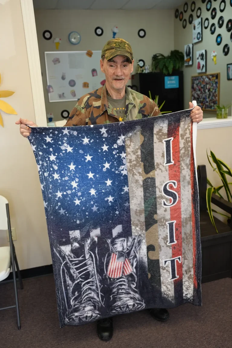 veteran holding a flag and smiling
