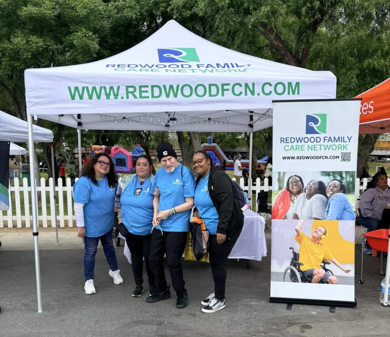 Cuidadores de Redwood con una persona bajo una carpa para eventos