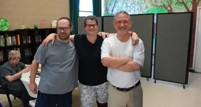 two individuals and a caretaker smiling